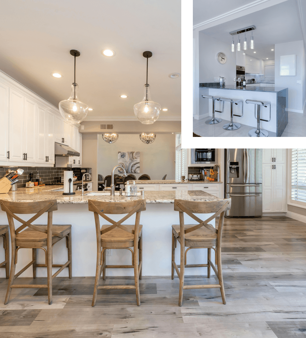 Modern kitchen with white cabinets, marble countertops, three pendant lights, and wooden bar stools. stainless steel appliances visible in the background.